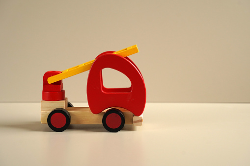 Toy wood fire car on a beige background. Kids natural eco toys. Developing toys. Special equipment