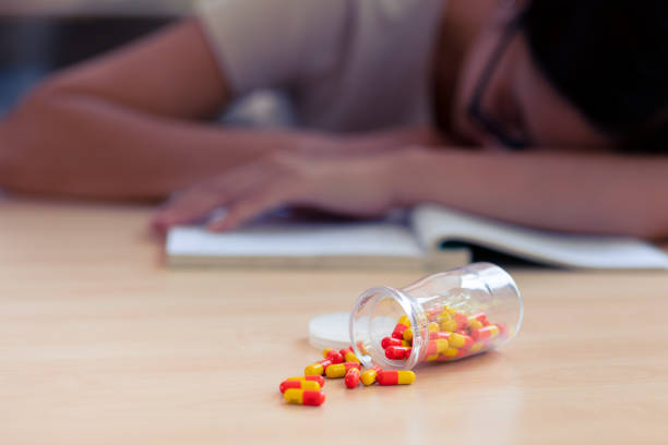 młody nastolatek z lekami, tabletką na kapsułkę leku w celu złagodzenia bólu lub zmniejszenia stresu związanego z ciężką nauką. - narcotic medicine pill insomnia zdjęcia i obrazy z banku zdjęć