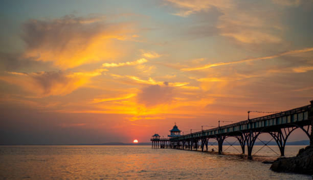 Amazing cloudy sky and sunset over pier.