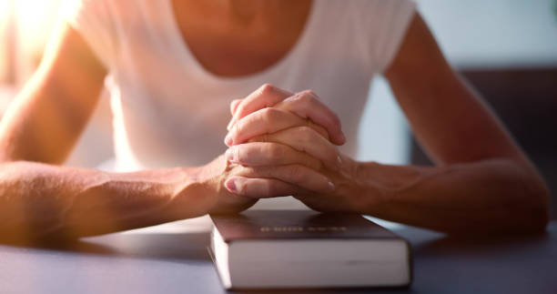 istock Sunlight Falling On Woman's Hand Over Holy Bible 1507229983