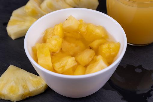 pieces of canned ripe yellow pineapple, canned pineapple fruit in sweet syrup, cut into thin pieces