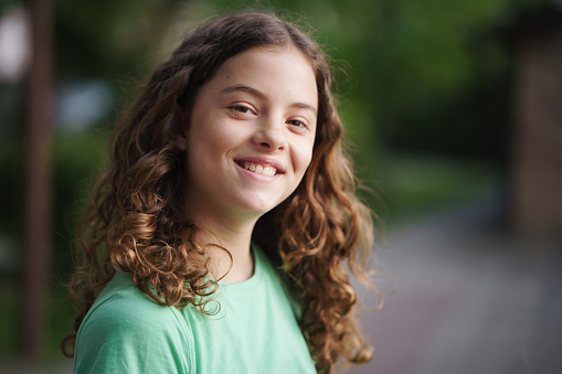 Portrait of happy cute kid, looking at camera and smiling. Screen view of little girl using gadget for video call, speaking at webcam and laughing during online virtual conference event. Head shot