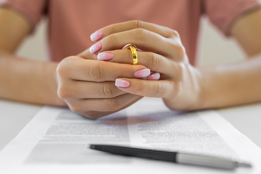 Female hands removing wedding ring