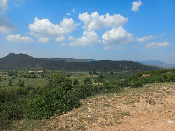istock Clouds shadow on hills, mountains range. Beautiful view of hills with shadows green grass trees village on mountains cliff under blue cloudy sky from another front hill. Meadow Landscape HD Wallpapers 1507253741