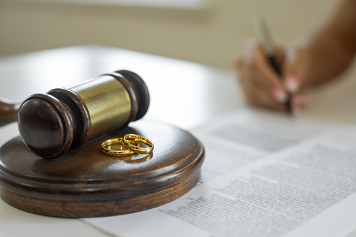 Weeding rings and gavel with a person signing a contract