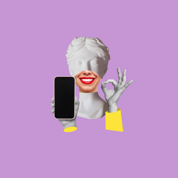 istock Young smiling antique statue's head holds mobile phone with blank black screen with copy space 1507267440