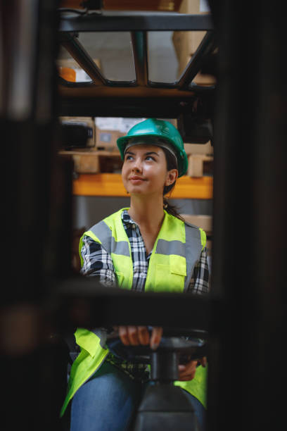 istock Efficient Warehouse Operations: Female Forklift Driver Poses and Drives Worklift at Distribution Warehouse 1507304852