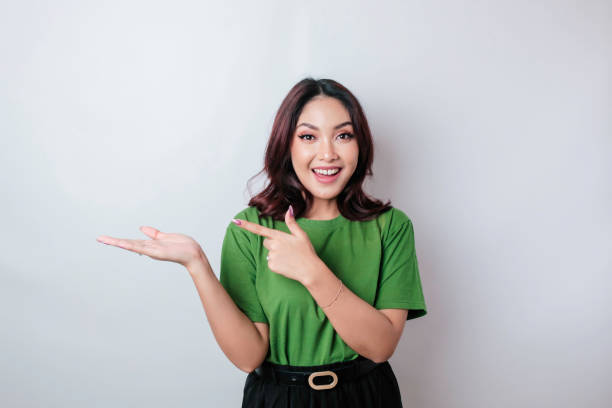 istock Smiling beautiful Asian woman pointing finger sideward to empty space isolated white background 1507315848