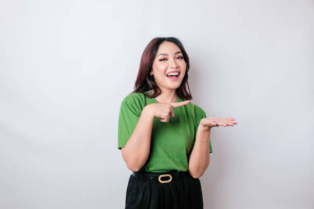istock Smiling beautiful Asian woman pointing finger sideward to empty space isolated white background 1507325765