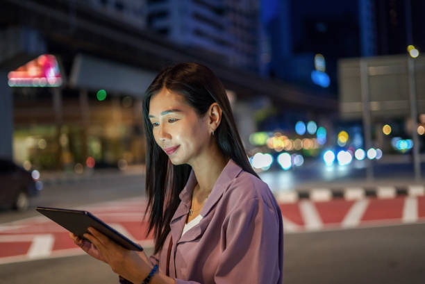 istock Businesswoman using digital tablet on city streets at night 1507341968