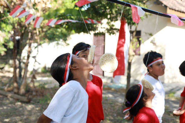 indonesian kids celebrate indonesia independence day with outdoor contest - eating child cracker asia imagens e fotografias de stock