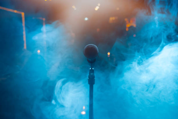 Studio microphone in neon lights. sound recording equipment. Microphone and stage lights. Concert and music concept.