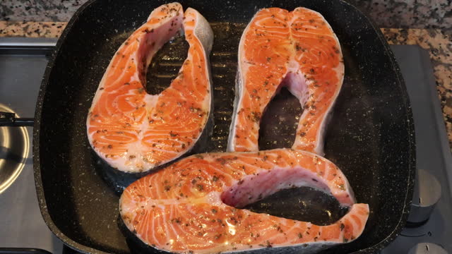 Fresh salmon fillet burning in pan in kitchen