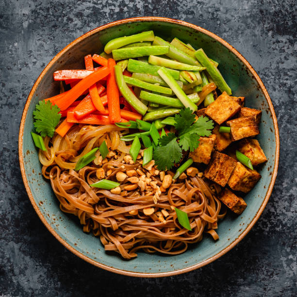 Soba noodles with vegetables and fried tofu in a bowl.