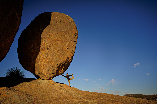 A young latin woman bouldering at an artificial climbing gym