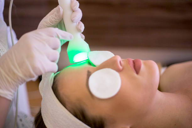 Woman at the spa getting a rejuvenation treatment on her face Woman at the spa getting a rejuvenation treatment on her face light therapy stock pictures, royalty-free photos & images