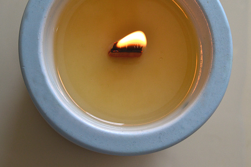 A lighted candle in a blue glass