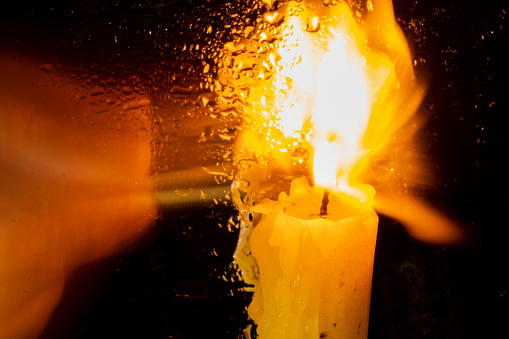 the flame of a church candle in a dark room