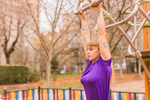 Wellness lifestyle outdoor in colorful park background. Health strength training muscle activity for latissimus dorsi body part. Attractive Argentinean preparing public exam for police or firefighter.