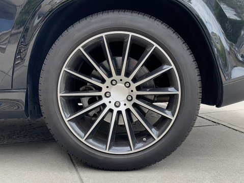 New shiny automotive wheel on light alloy disc isolated on white background