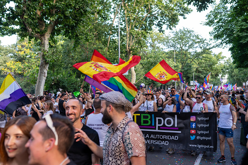 Madrid, Spain. 01 July 2023 LGBT community at a gay parade in summer day. Pride month party celebration on a city street. People with bright flags outdoors.