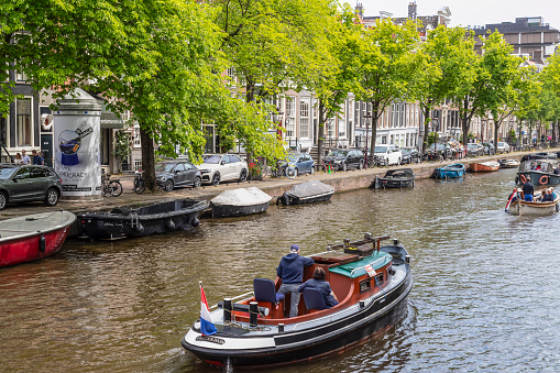 Amsterdam, Netherlands, May 28, 2023; Sailing with a small boat through the Amsterdam canals.