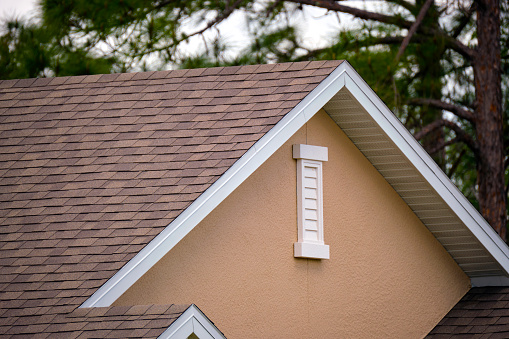 Closeup of house roof top covered with asphalt or bitumen shingles. Waterproofing of new building.