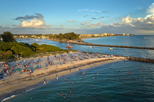 Aerial view of Nokomis beach in Sarasota County, USA. Many people enjoing vacation time swimming in gulf water and relaxing on warm Florida sun at sunset.