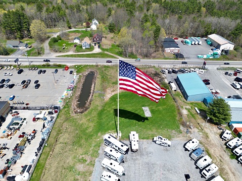 An aerial shot of a parking lot with an American flag waving in the foreground