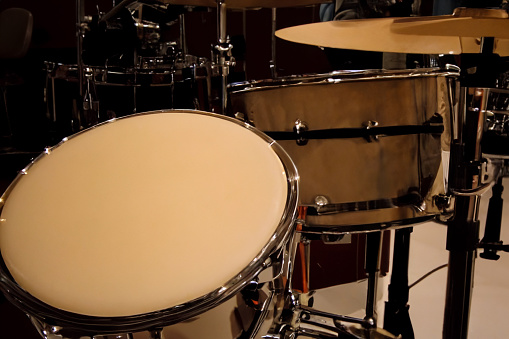 Bass drum and cymbals in foreground and French Horns in the background. 