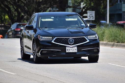 Houston, Texas USA - June 28, 2023 - A black Acura luxury sedan cruising on Allen Parkway in Houston