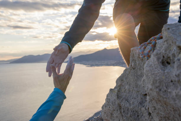 istock Climber offers helping hand to teammate on steep cliff above sea 1507824802