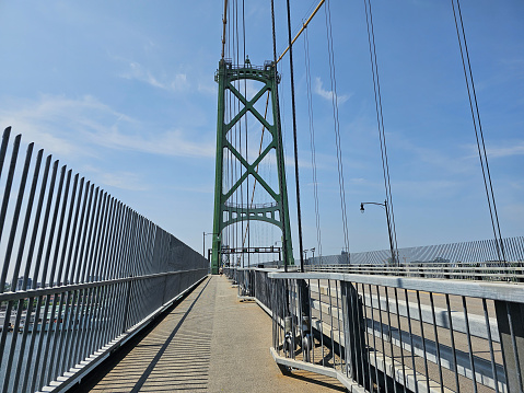 A walkway across a large bridge on a clear day.