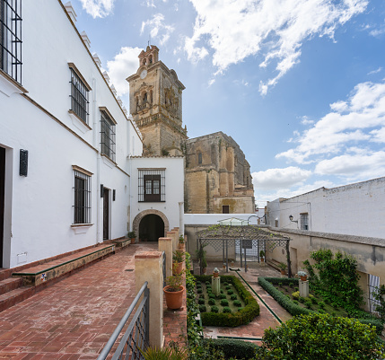 Arcos de la Frontera, Spain - Apr 10, 2019: Mayorazgo Palace Courtyard and San Pedro Church - Arcos de la Frontera, Cadiz, Spain