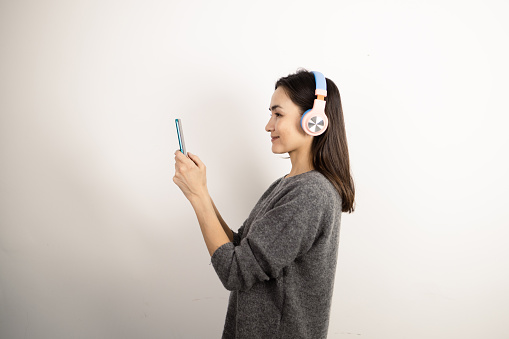 Studio portrait of a happy woman listening to music