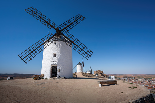Consuegra, Spain - Mar 28, 2019: Windmills and Consuegra Castle (Castle of La Muela) at Cerro Calderico - Consuegra, Castilla-La Mancha, Spain