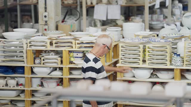 People at work in a large ceramics manufacturing warehouse