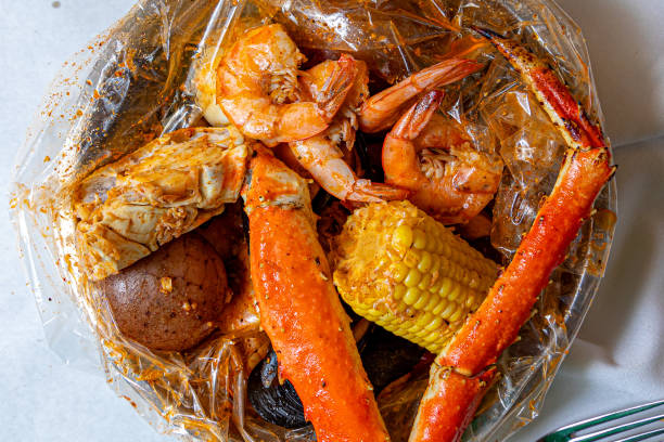Wide view of steamed crab legs with garlic butter, lemon, and parsley flakes
