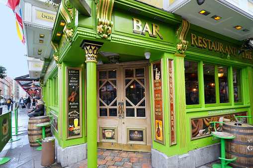Dublin, Ireland - March 2023:  Colorful traditional Irish pub in Dublin with people sitting outside