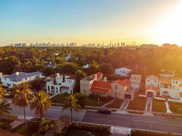 An Elevated View above Homes in Bayshore Neighborhood of Mid Miami Beach, with a Distant Skyline View of Miami, Florida, USA at Sunset