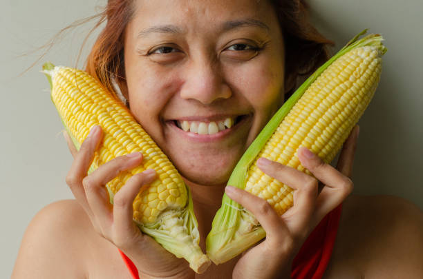 istock Asian woman holding corn and smiling 1508309636