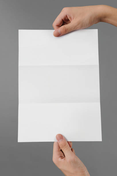 istock Hand holding a blank a4 size paper isolated on grey background. 1508318749