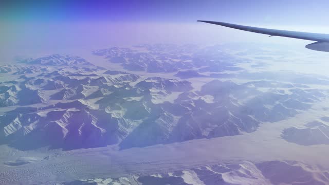 Snowy mountains and glaciers in the Arctic seen from an airplane