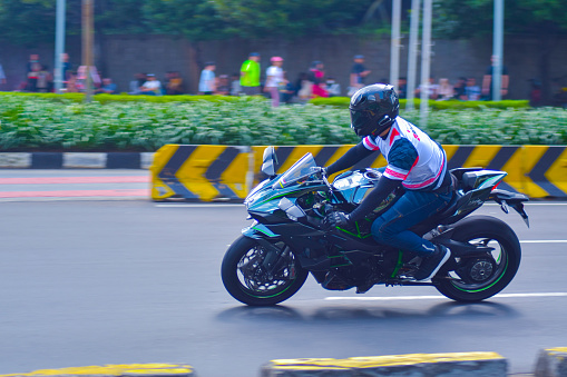 a man rides a Kawasaki Ninja motorbike in the Jakarta HI Roundabout area