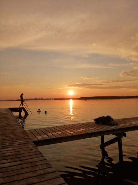 istock a woman paddle boarding in a lake at sunset with ducks 1508446221