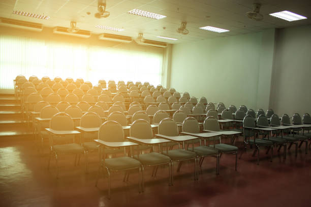 Classroom or lecture room empty with rising sun in morning. Many chairs installed in college or university.
