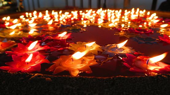 Colorful flower candles floating on water for pray happy and lucky in thai buddhism culture.