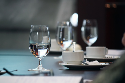 Water glass with water on dinner table restaurant. Business greeting or meeting concept.