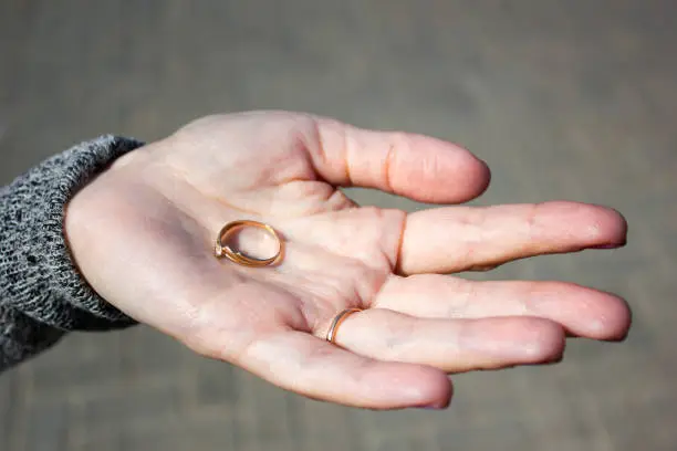 Photo of Girl holds the ring in her palm.Woman holds a ring in her hand. Young girl holds a ring in her palm.