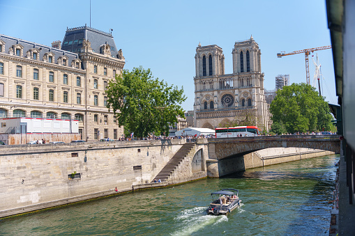 Tourist cruise ship on the Seine River and Notre Dame Cathedral